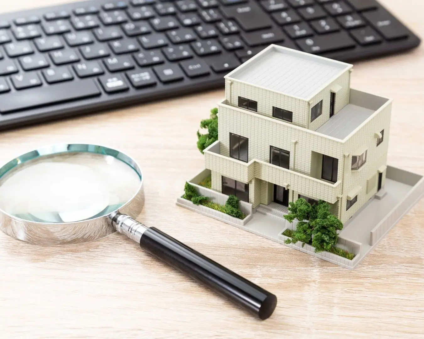 estate-planning-property-protection-williamsville-ny Miniature house model with magnifying glass representing estate planning and property protection in Williamsville NY