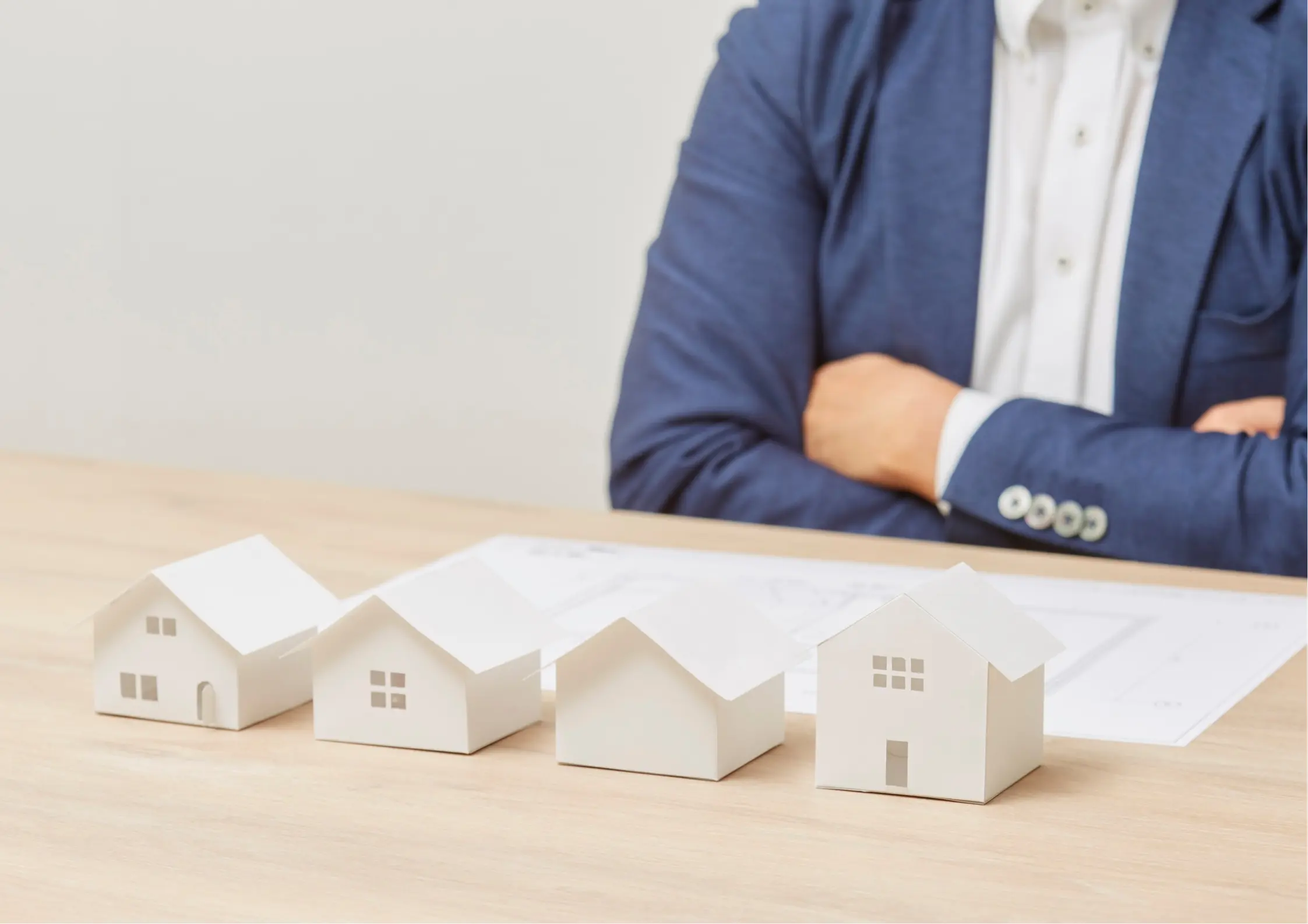 Estate planning advisor standing behind a row of white model houses, representing family estate and property planning in Lancaster, NY