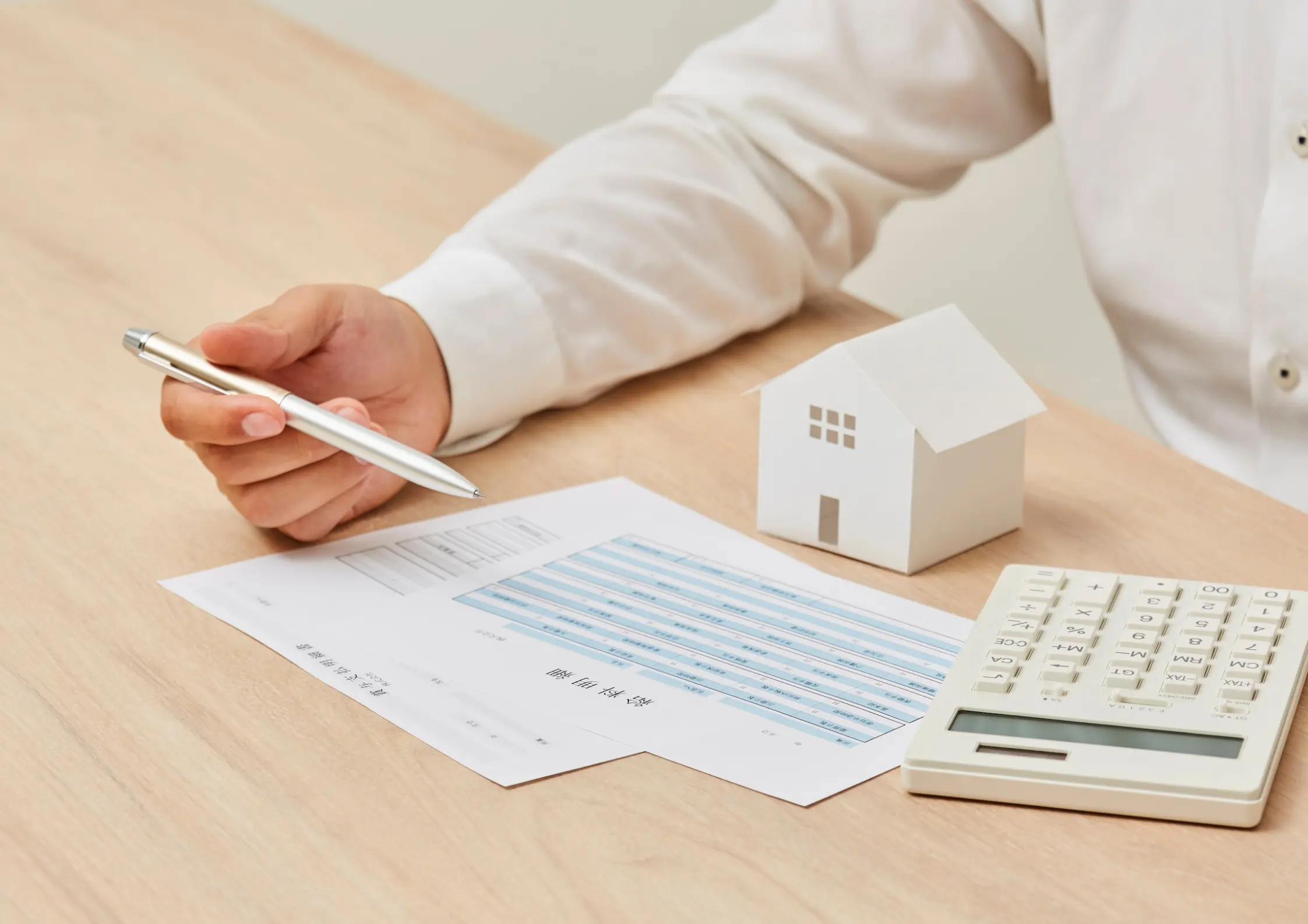 Advisor reviewing estate planning documents with a house model and calculator in East Amherst, NY