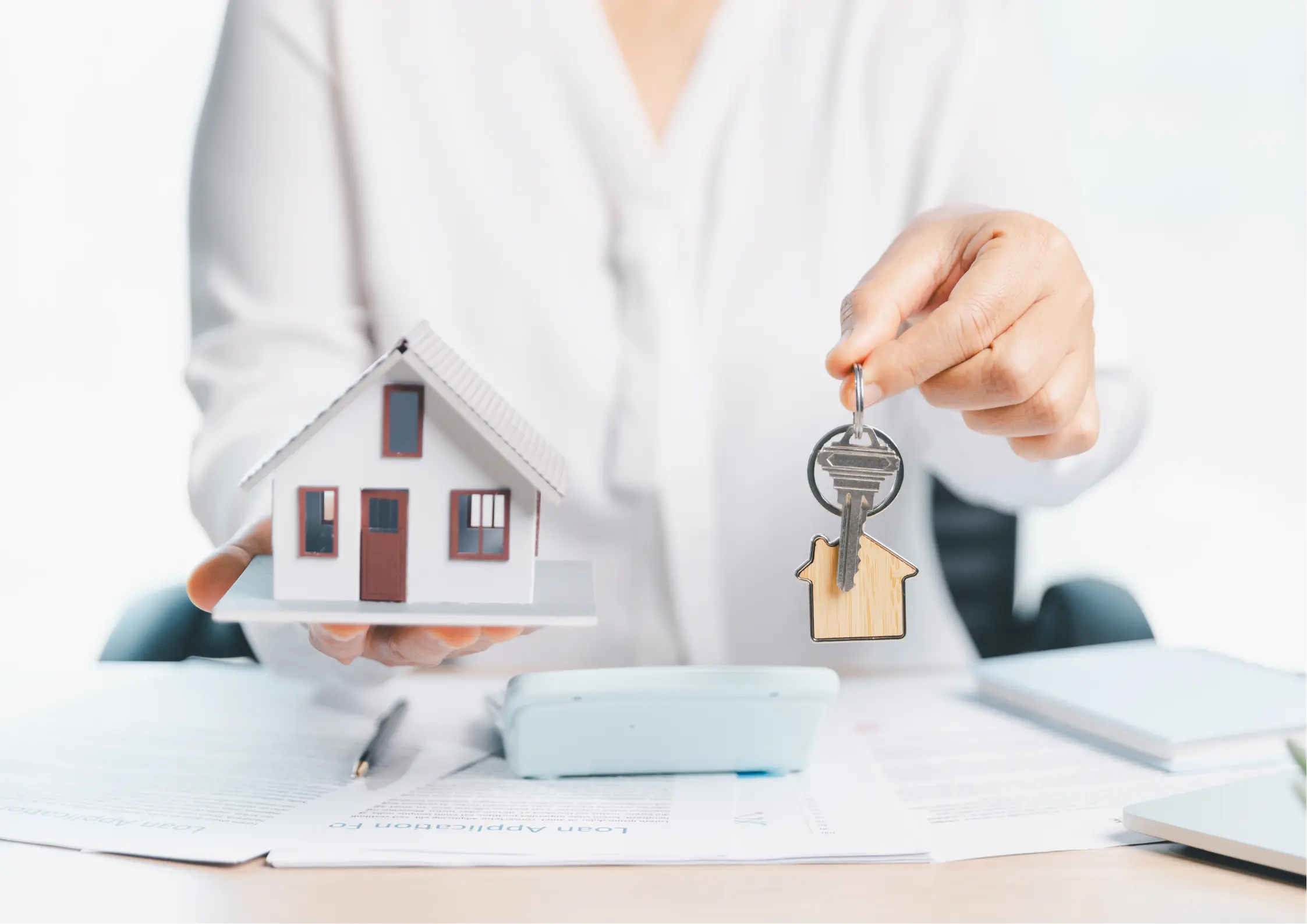 Estate Planning in Cheektowaga, NY Advisor holding a model home and house keys, representing passing on a home through estate planning in Cheektowaga, NY